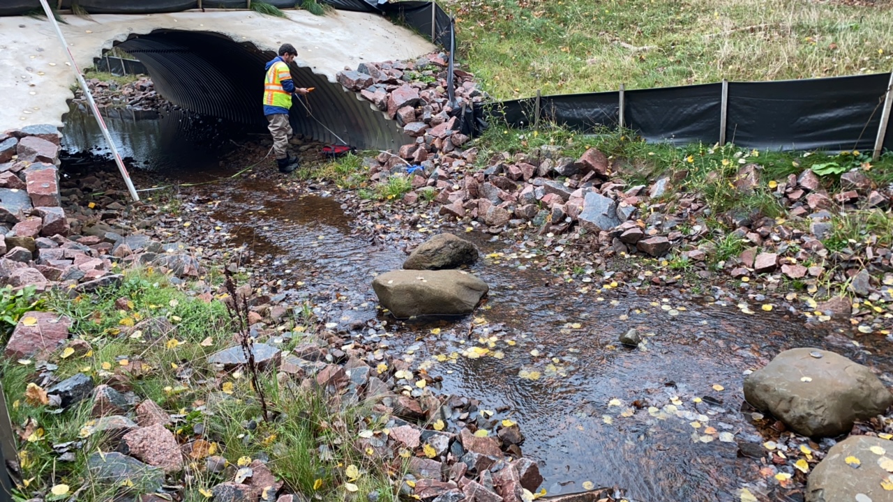 Shallow stream flows into a culvert